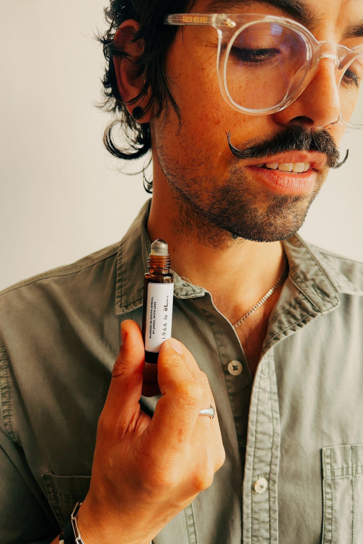 Man holding an essential oil perfume.