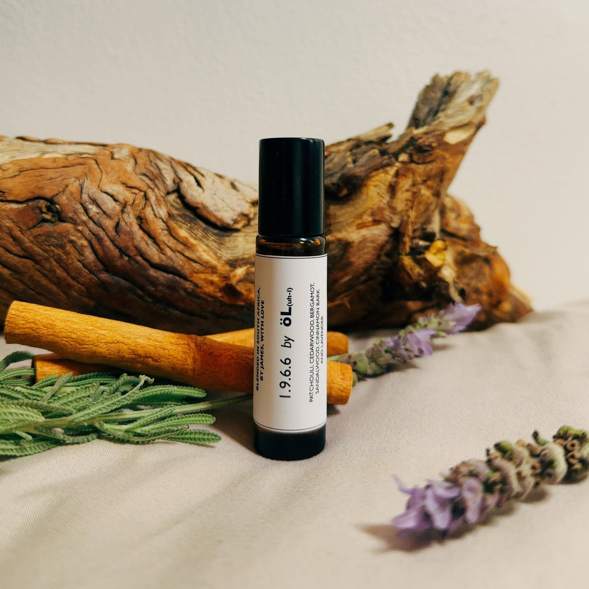 1.9.6.6 bottle with a label on a textured surface with natural elements like cinnamon sticks and lavender.