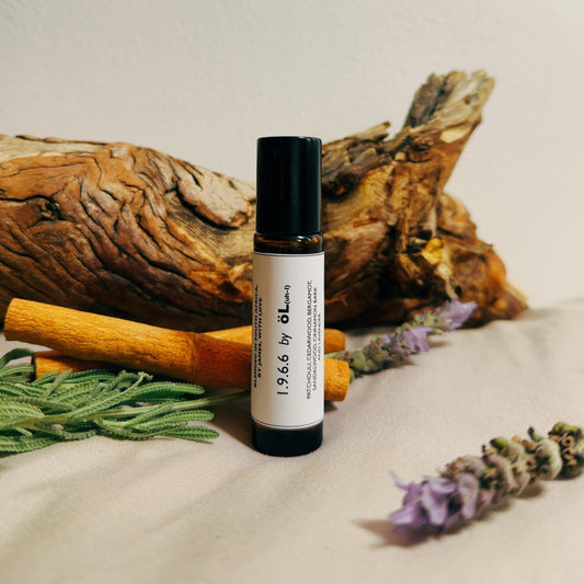 1.9.6.6 bottle with a label on a textured surface with natural elements like cinnamon sticks and lavender.